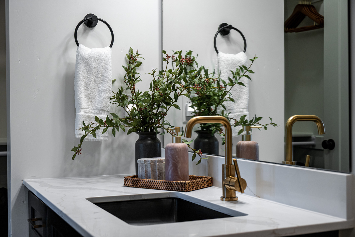 Thoughtful bathroom details and warm brass fixtures add a polished touch to the space.