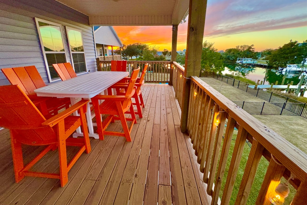 Private backyard dock with boat lift and fillet table, fenced-in backyard, fire pit with Adirondack chairs, hammocks, propane grill, picnic table, outdoor shower, expansive waterfront back deck with table and seating, neighborhood boat ramp and dock