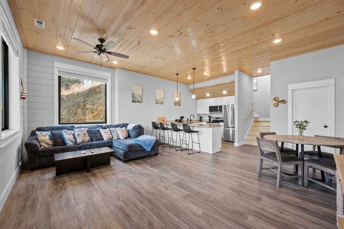Bright, open living area with comfortable seating and plenty of space to relax. Natural light, warm wood ceilings, and an easy flow make this a welcoming space to unwind together.
