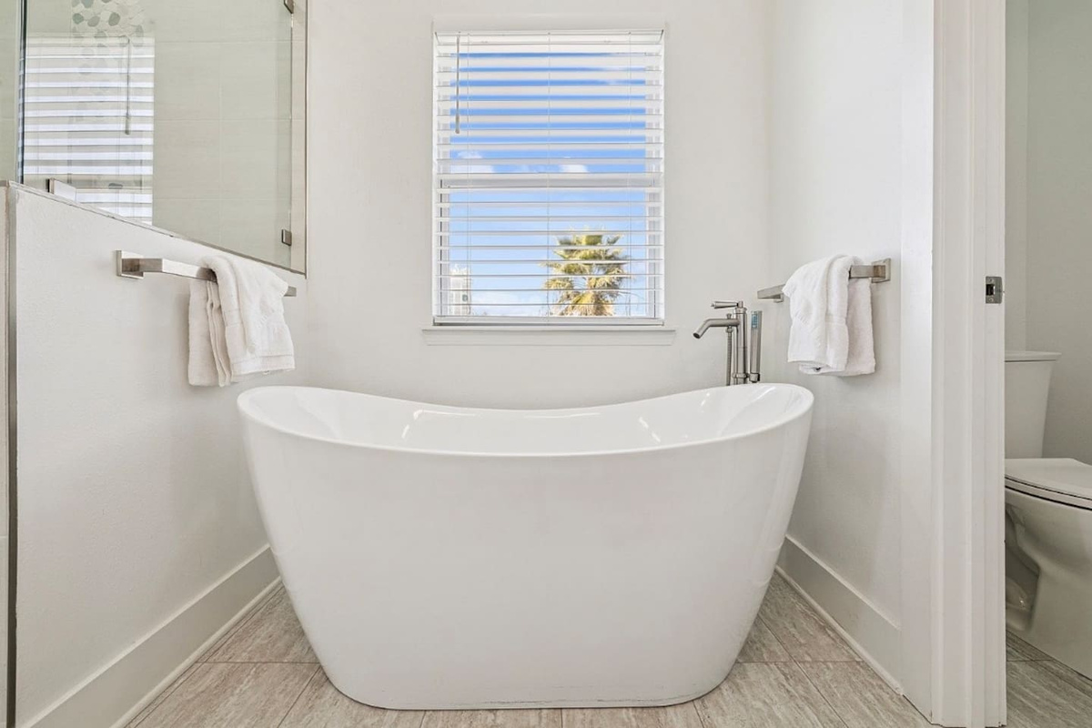 Relaxing standalone soaking tub in the primary en-suite bath designed for ultimate unwinding after a beach day