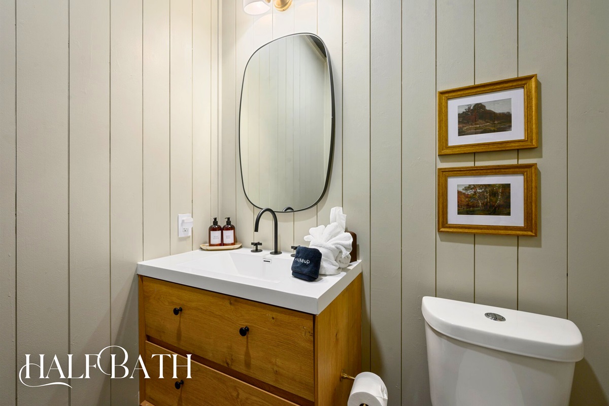 The half bath sits conveniently near the main living spaces, offering a clean, stylish spot for quick refreshes