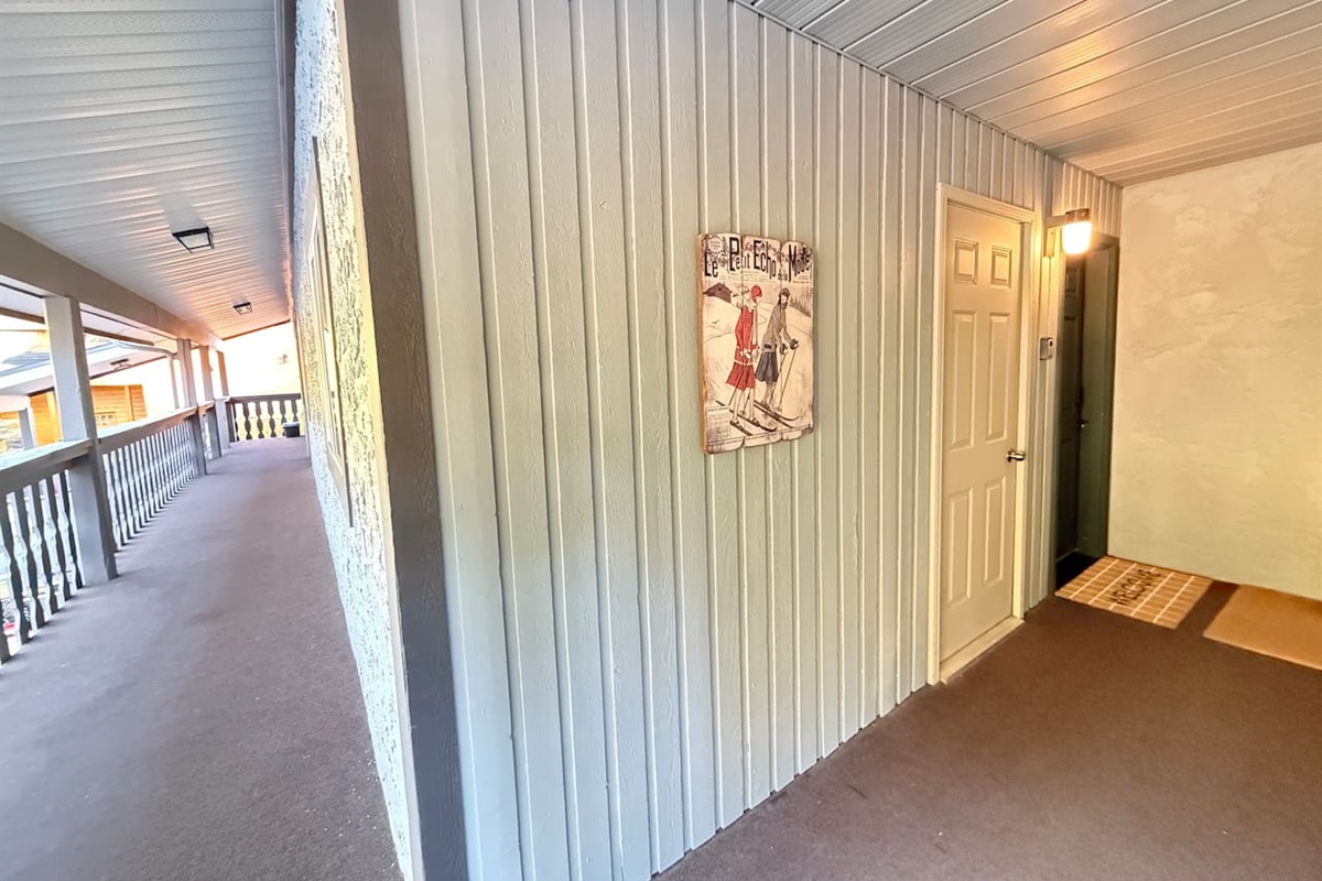 This is the door to the townhouse. The welcome mat is set in front and has a sign that says Suite Stays 855 on the blue door.