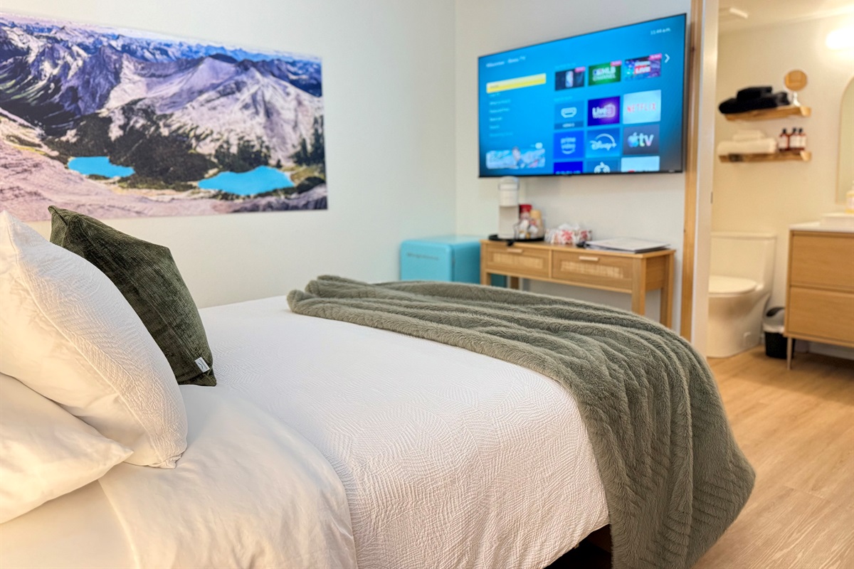 Relaxation Zone: The comfortable queen bed is complemented by mountain imagery of local lakes and entertainment options for the perfect mountain retreat.
