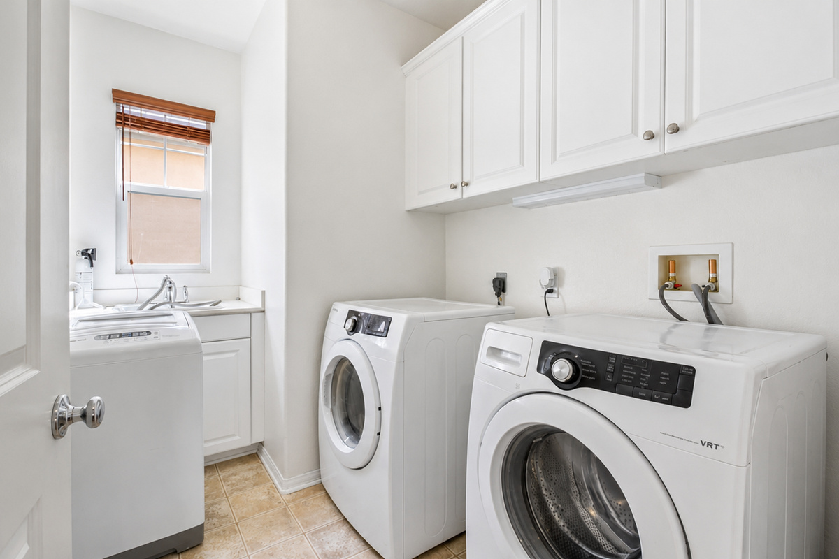Laundry room with washer, dryer, sink, and cabinet storage for easy longer stays.