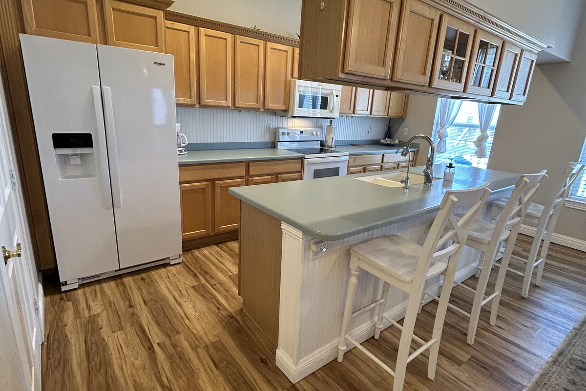 Fully equipped kitchen with everything you need for meal prep and family dinners. Features include full-size appliances, ample counter space, abundant cabinet storage, and a convenient breakfast bar with seating.