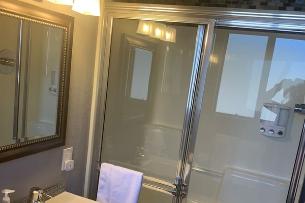 This shower has the rain feature! We use dispensers for shampoo, conditioner, and shower gel to do our part to reduce plastic waste. 