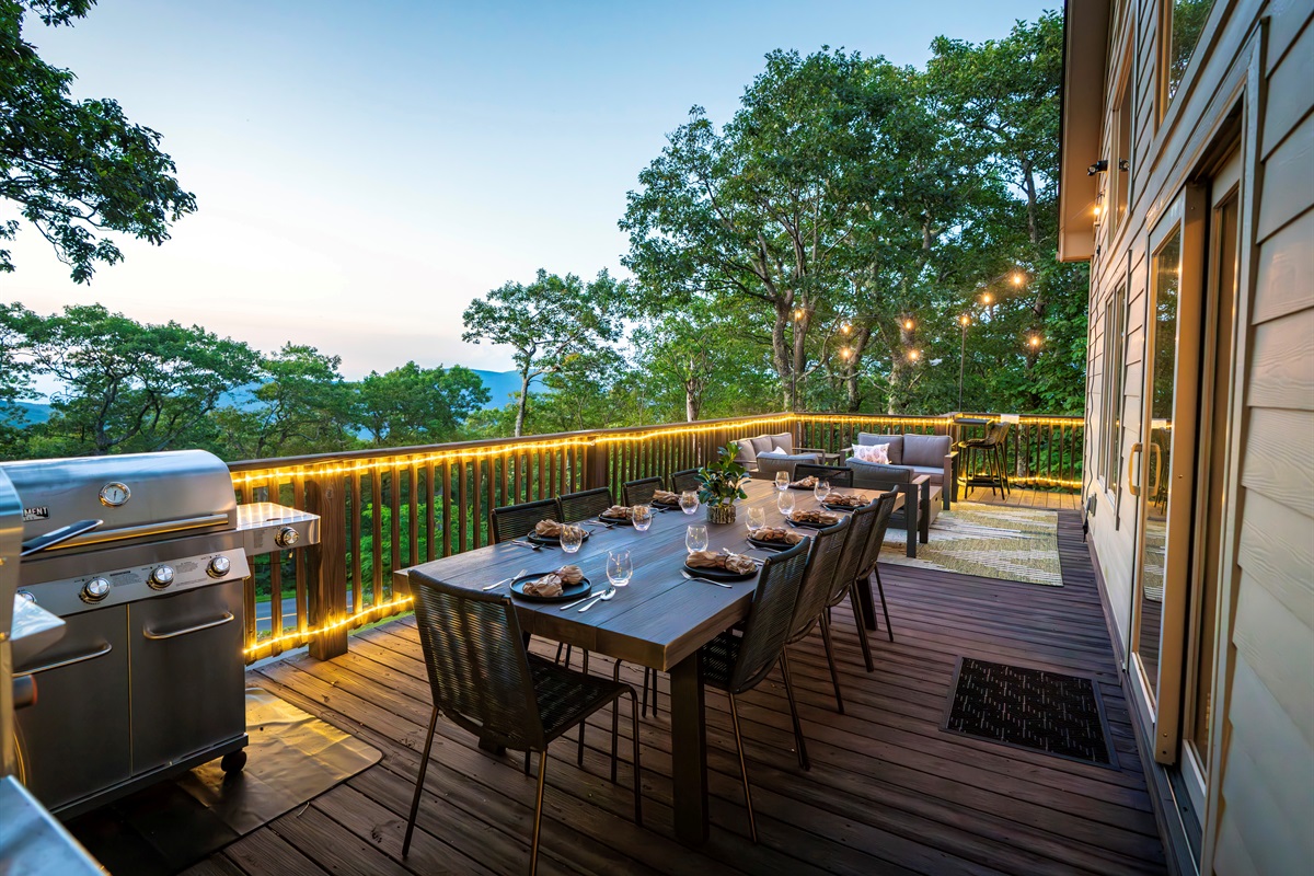 Twilight on the deck — mountains fading in the distance, wine glasses catching the glow of string lights, dinner sizzling on the grill. This is what gathering should feel like