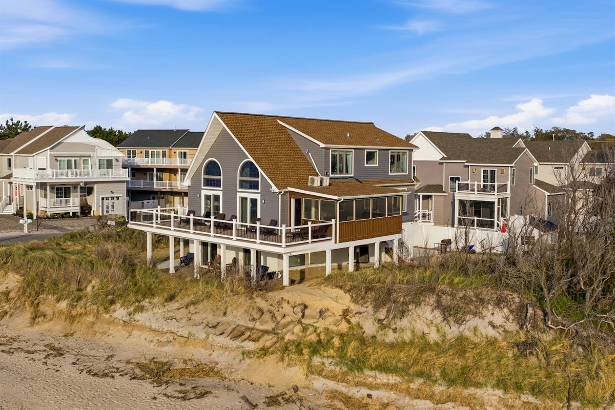 Enjoy the perfect beachfront escape at this stunning property, uniquely positioned for direct shoreline access and sweeping coastal views from its expansive elevated deck.