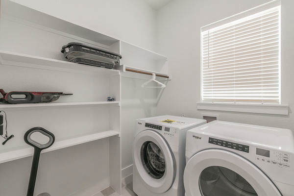 Laundry room with full sized washer and dryer and storage space