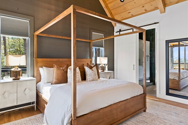 Unwind in the elegant primary bedroom that marries rustic charm with modern comfort, a perfect retreat after a day of adventure.