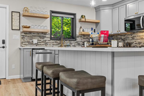 Center island serves as the heart of the kitchen, featuring comfortable barstool seating for up to six people