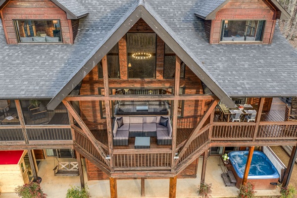 The back of the beautiful "Blessed Sunset" mountain retreat home overlooking the back yard! Stunning A-frame, wrap-around porch, screened-in patio, outdoor fireplace, outdoor dining table, sauna, hot tub, outdoor couch, and more!