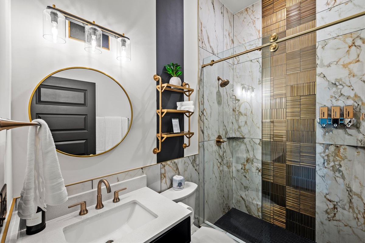 A masterfully designed en-suite bathroom, complete with a glass-enclosed walk-in shower and modern finishes.