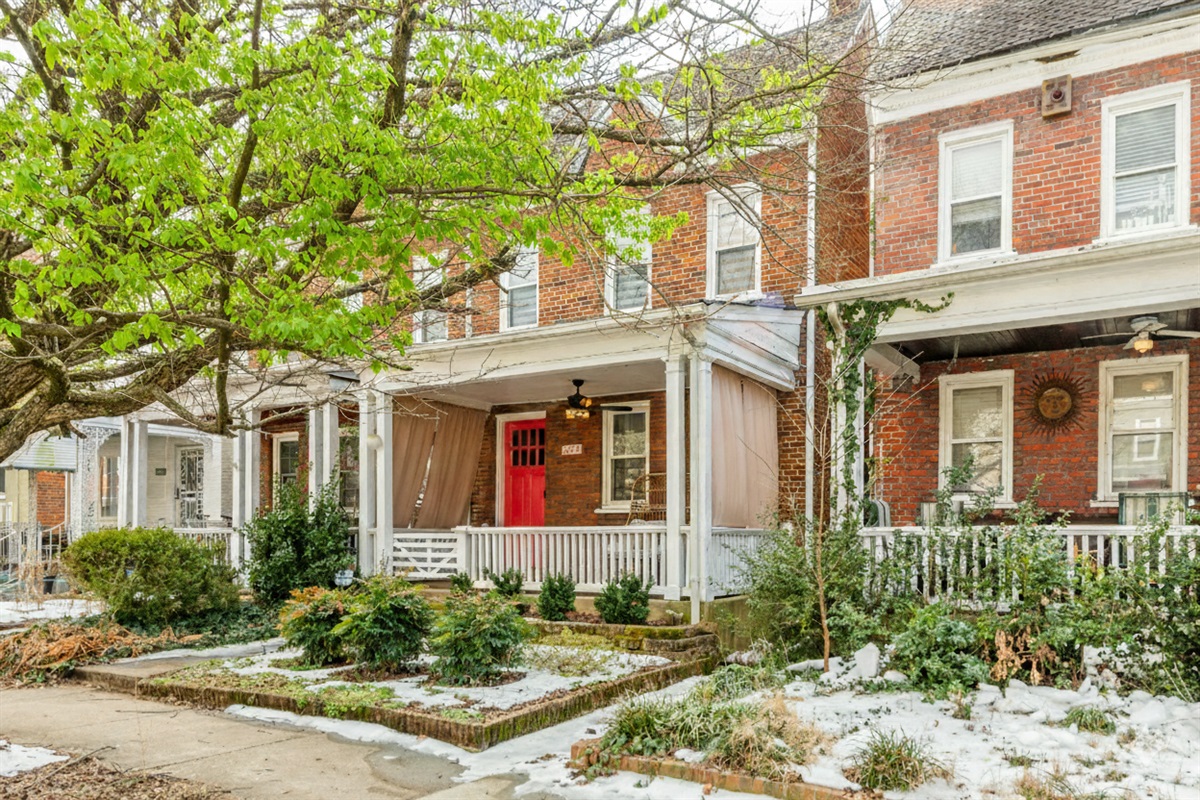 Charming Exterior: Enjoy the vibrant red door and lush greenery that welcomes you home!