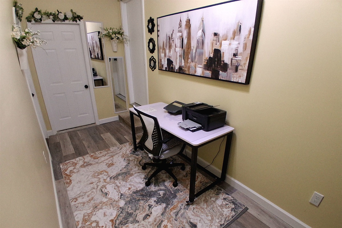 This private, lockable office doubles as a bedroom. The lightweight, wheeled desk easily rolls in front of the laundry room door to clear space for a full-size floor mattress on the rug. Linens, pillows, and a mattress cover are provided.
