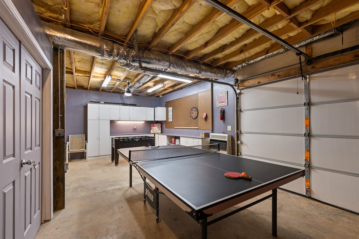 The converted garage game room is packed with fun, offering table tennis, arcade games, foosball, and darts for endless entertainment.