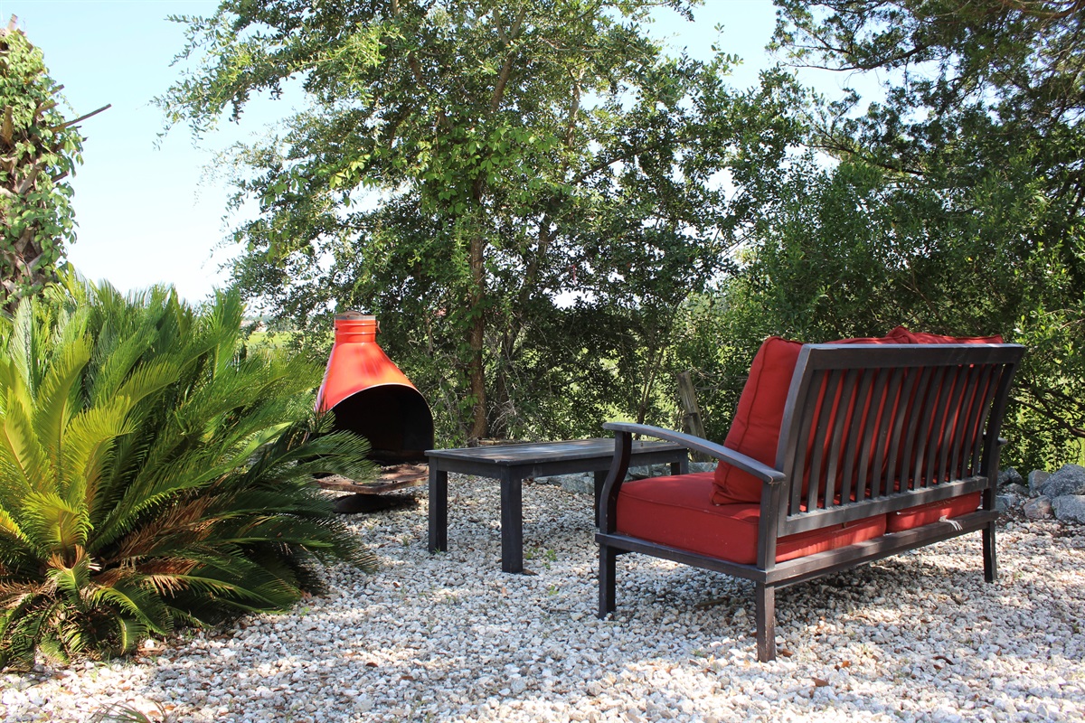 Cozy up beside the chiminea in this peaceful garden nook—perfect for evening chats under the stars.