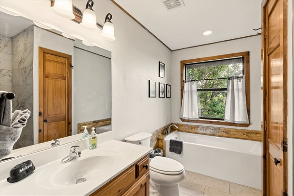 Full bathroom attached to the bedroom on the main level comes with a tub and a separate shower booth