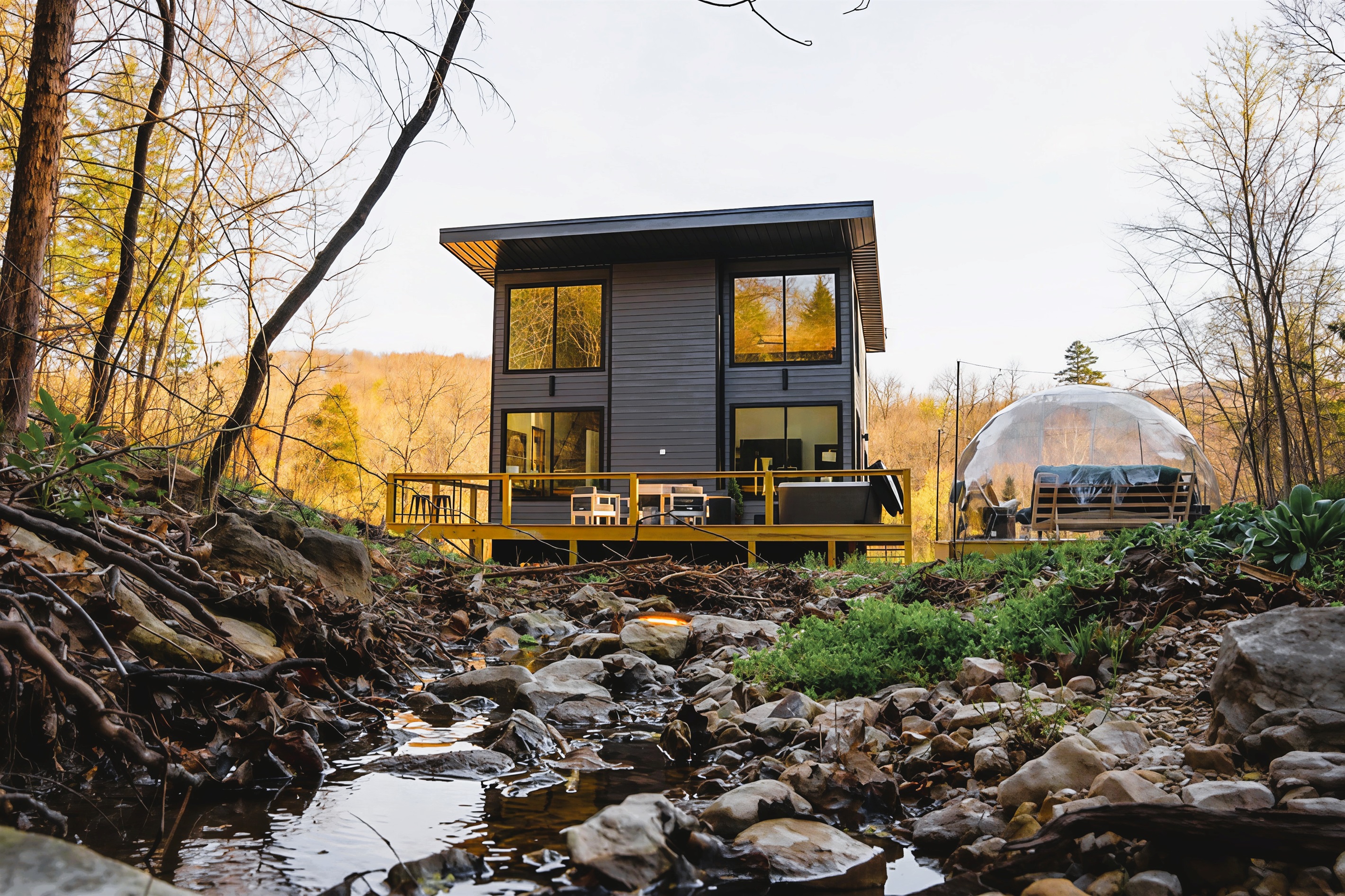 A one-of-a-kind glass cabin perched directly over a flowing Ozark creek