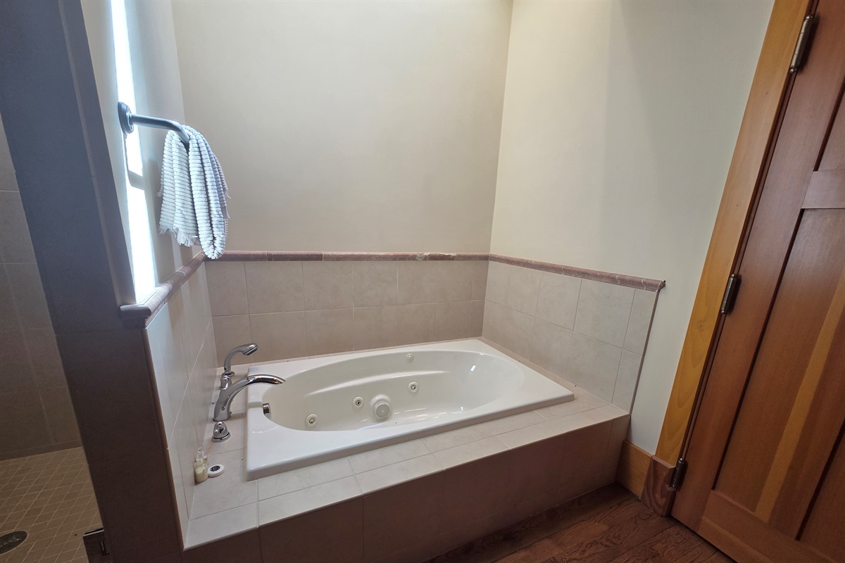 The carriage house includes its own private bathroom, separate from the main house, with a soaking tub and a large walk-in shower for added comfort.