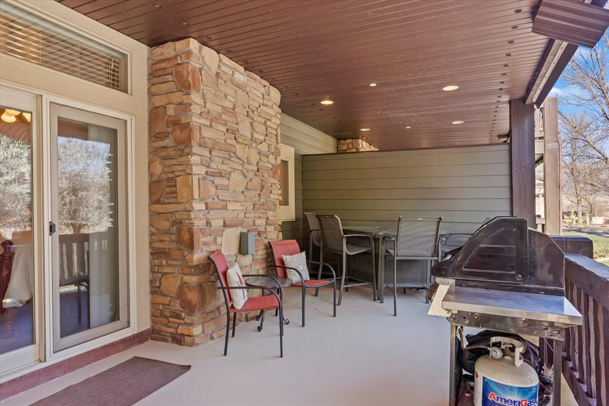A covered patio with grill and seating, offering a private outdoor space perfect for dining and relaxing in the fresh mountain air.