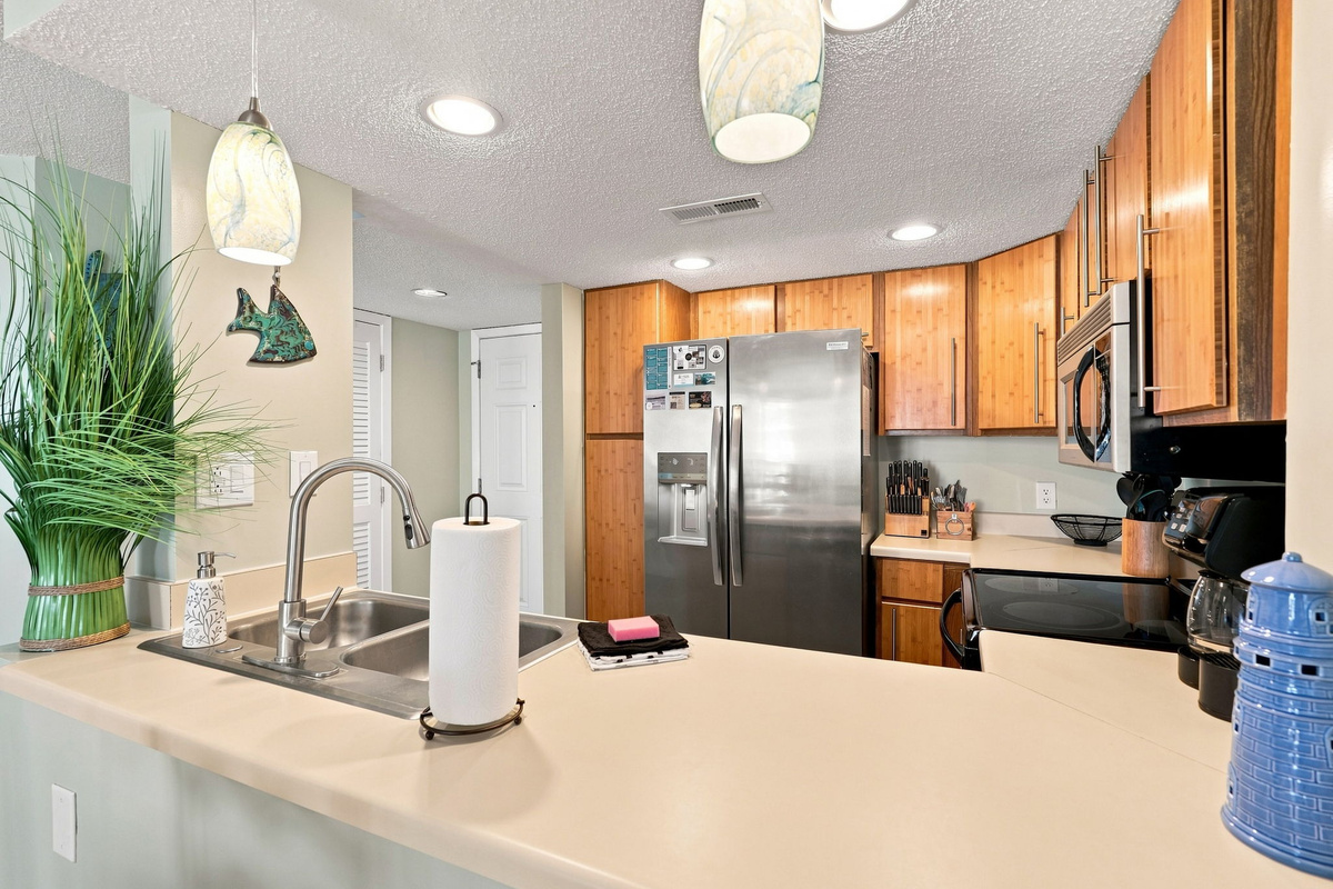 View from behind the kitchen counter toward the warm, well-lit entry hallway and dining space.