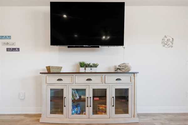 The living room has a 65-inch Roku TV. Roku TVs allow you to view your own streaming shows and will log you out automatically when you leave.