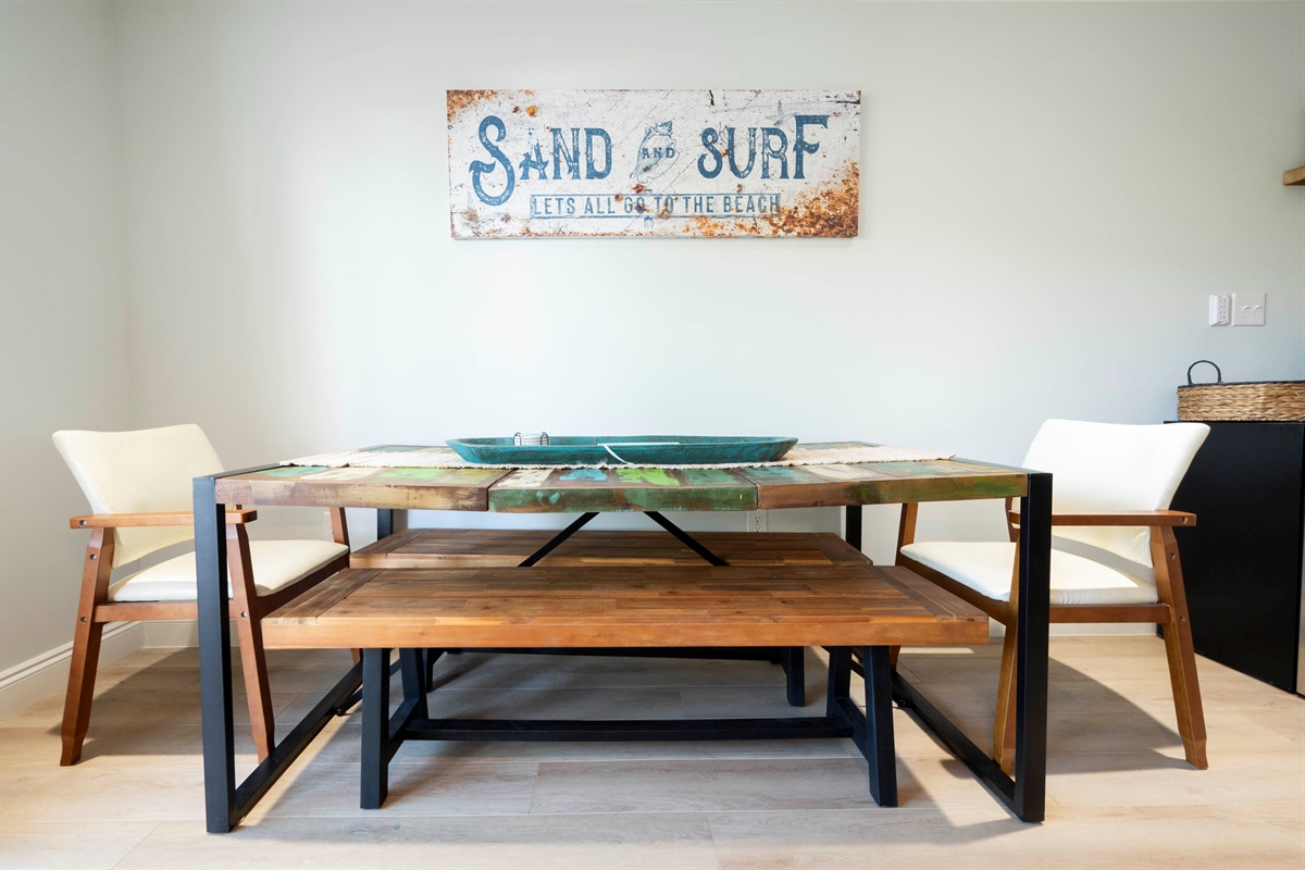 Cozy beach-themed dining: Rustic table, inviting chairs, and seaside vibes!