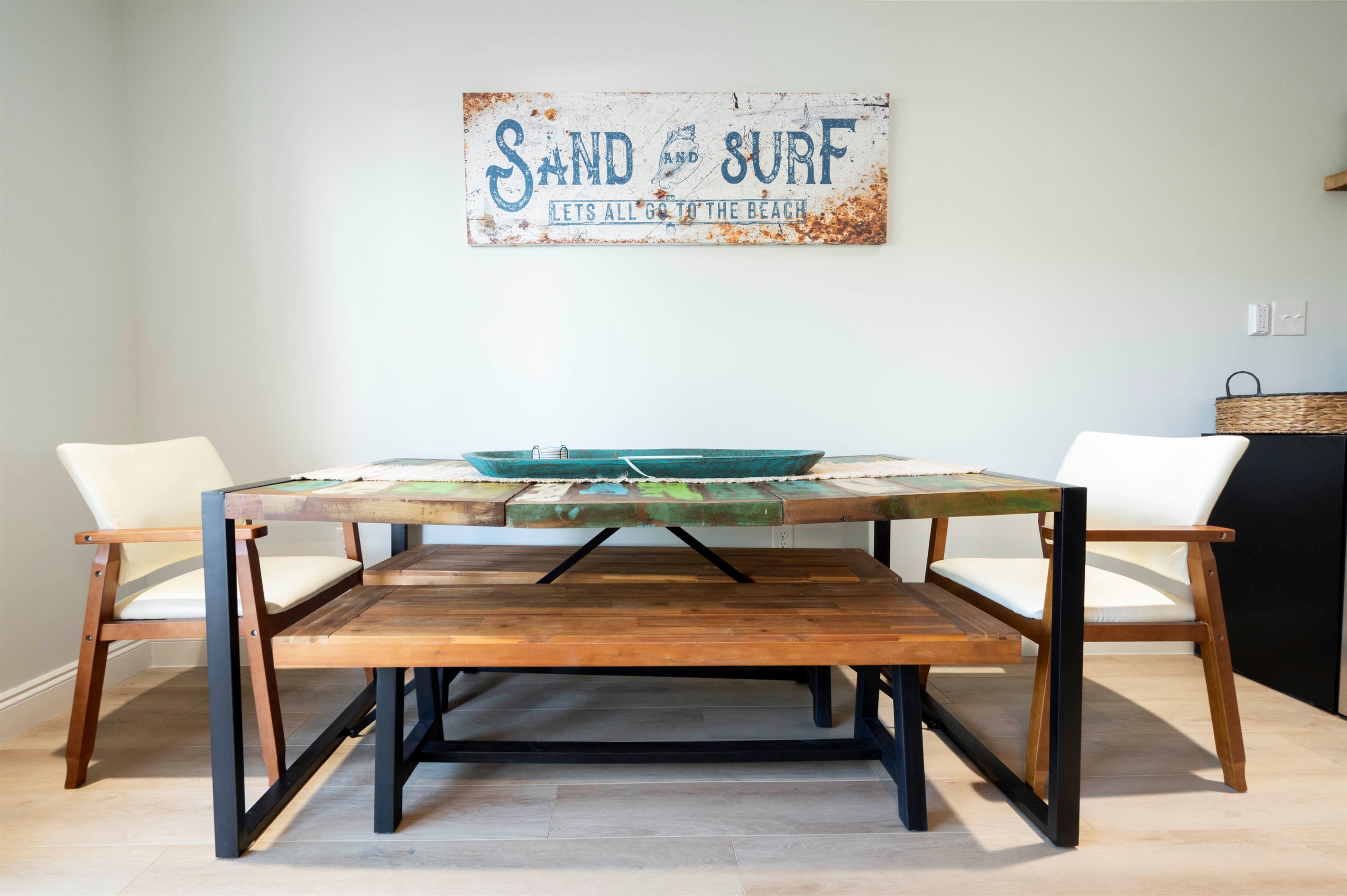 Cozy beach-themed dining: Rustic table, inviting chairs, and seaside vibes!
