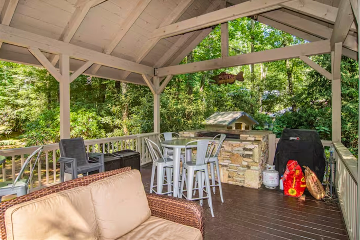 Covered Porch with Large Stone Grill and Seating Options