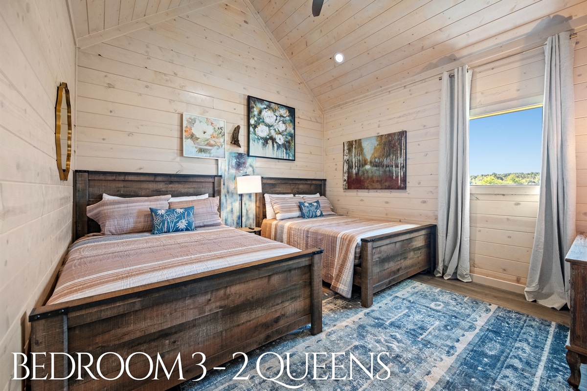 Bedroom 3 with two queen beds, cozy décor, and natural light.