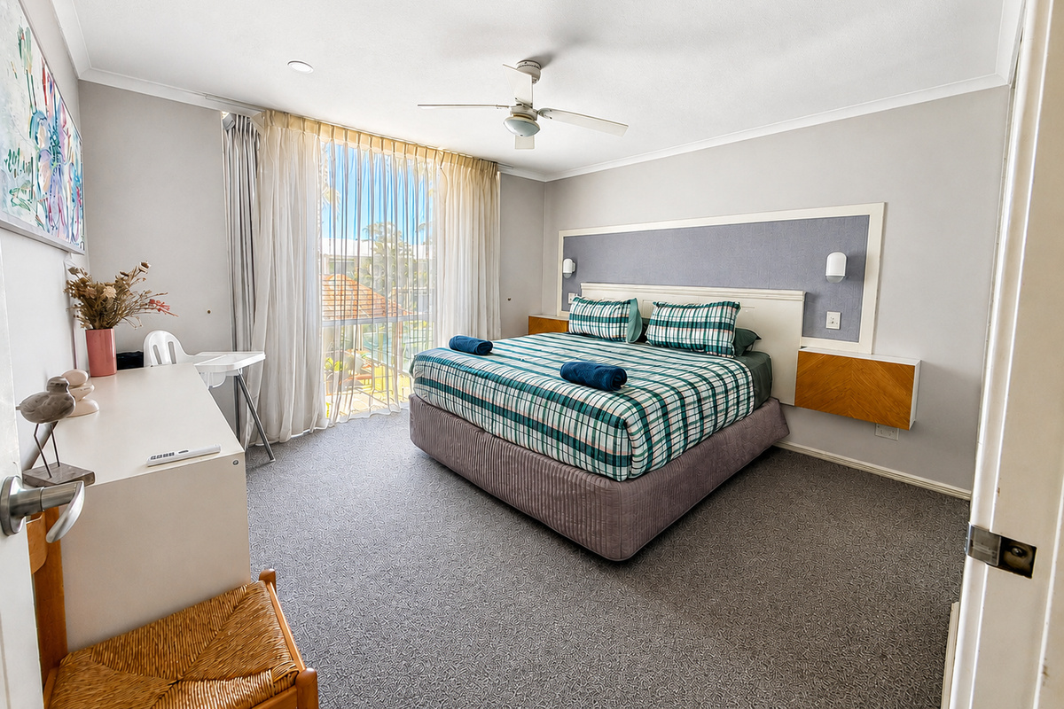 The main bedroom adds a dedicated sleeping space to Sea Breeze Apartment’s two-bedroom layout, positioned separately from the shared living and kitchen areas.