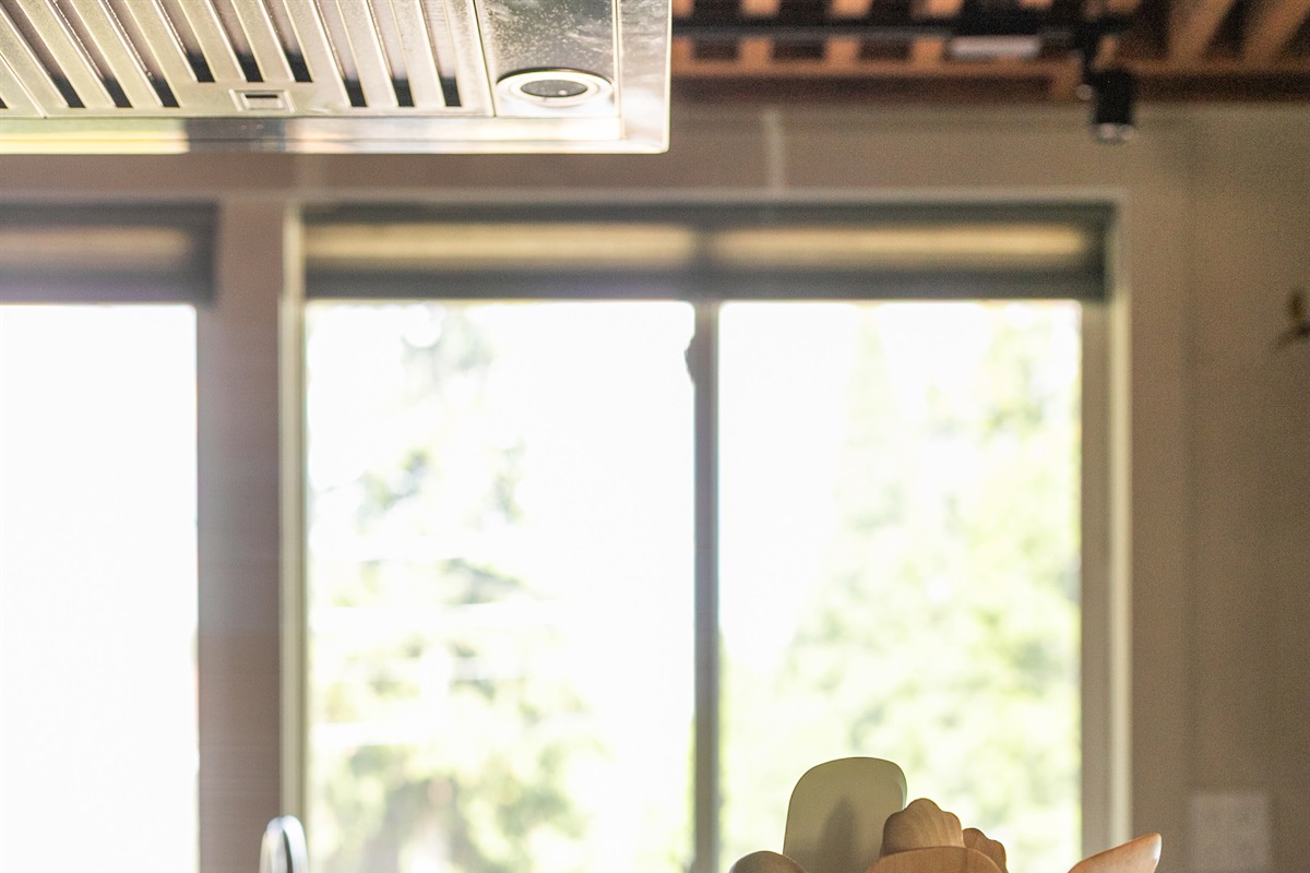 Sunlight streams through the kitchen windows, casting a warm glow across the space and opening the view to the backyard. It’s a bright reminder that whether you’re cooking, gathering at the island, or simply enjoying a quiet moment.