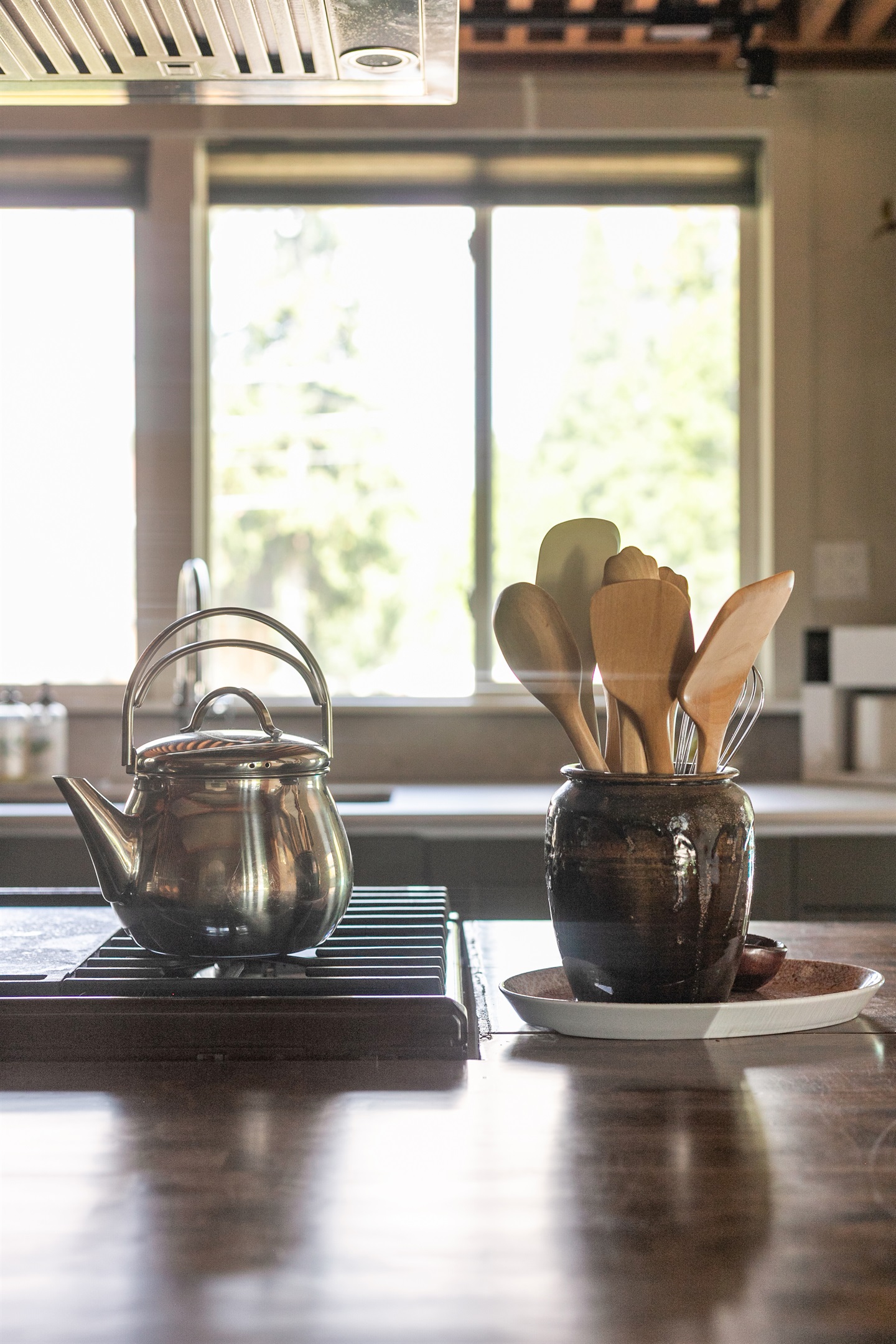Sunlight streams through the kitchen windows, casting a warm glow across the space and opening the view to the backyard. It’s a bright reminder that whether you’re cooking, gathering at the island, or simply enjoying a quiet moment.