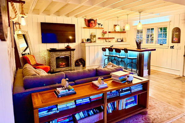 Cozy up with loads of books, high end sleeper sofa, electric fireplace, large smart TV, and Bluetooth speaker. 