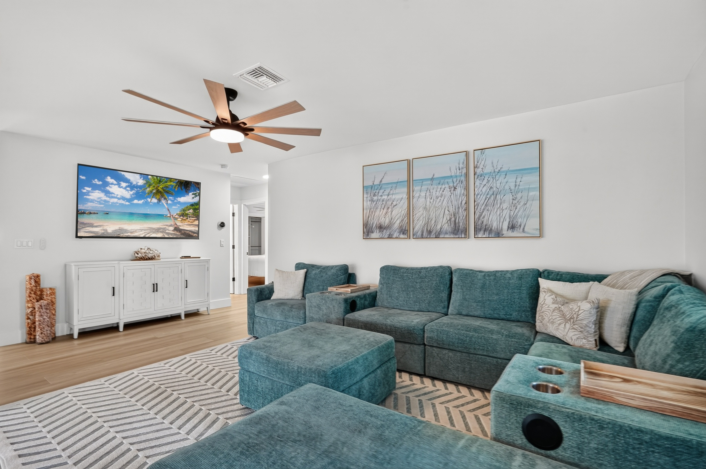 Relax in the bright, spacious living room with an oversized chaise sectional and a 75-inch smart TV.