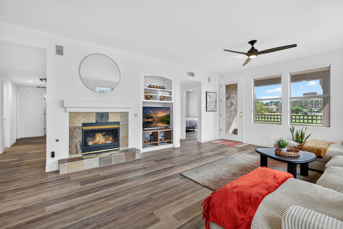Open living area with comfortable sectional seating, TV, fireplace, and easy flow to the dining and kitchen spaces.