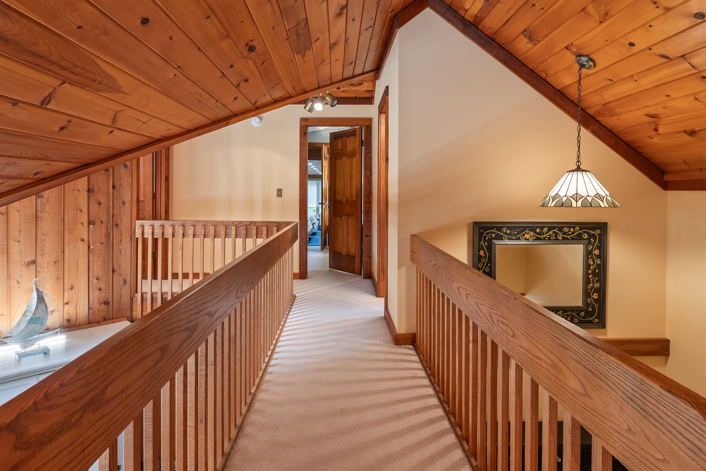 Warm wood hallway leading to upstairs rooms — a cabin-style touch full of character and charm.