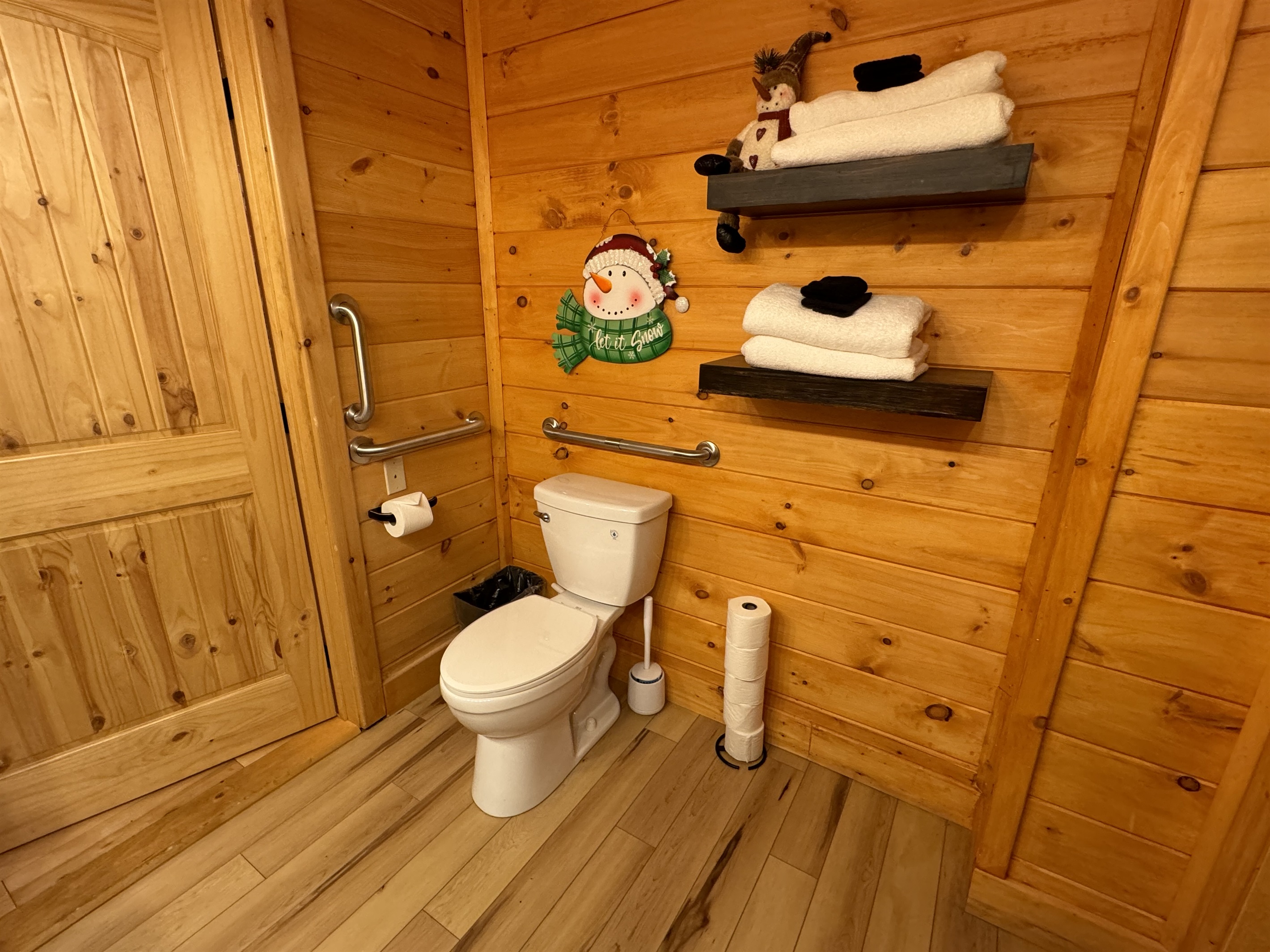 Toilet area in Snowman bathroom.  Large door, lots of space and two grab bars.