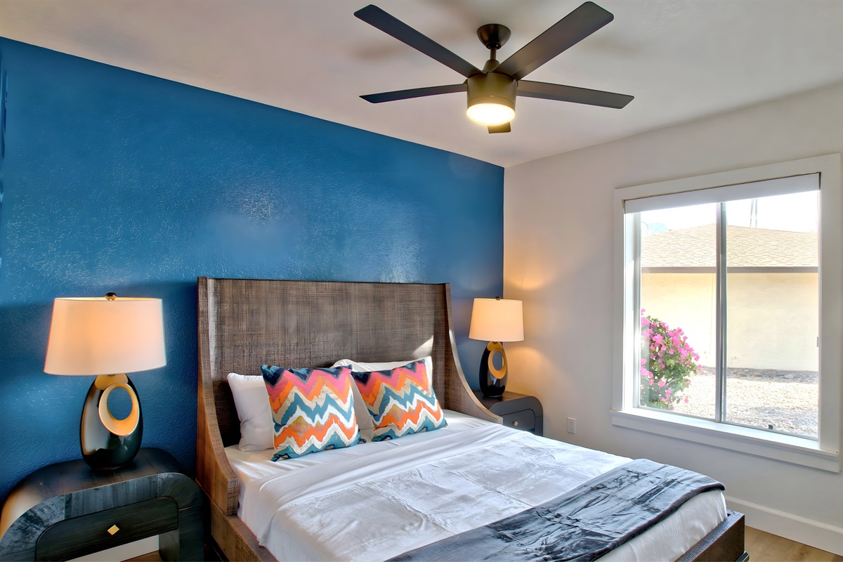 Spacious 2nd bedroom with queen size bed and vivid blue accent wall