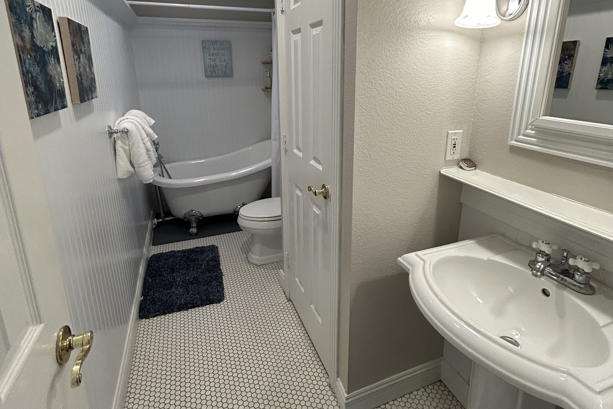 King Suite Ensuite Bathroom (Ground Level) features a classic clawfoot soaking tub and a relaxing spa-like atmosphere. The perfect place to unwind and recharge after a day at the beach, pool, or exploring South Padre Island.