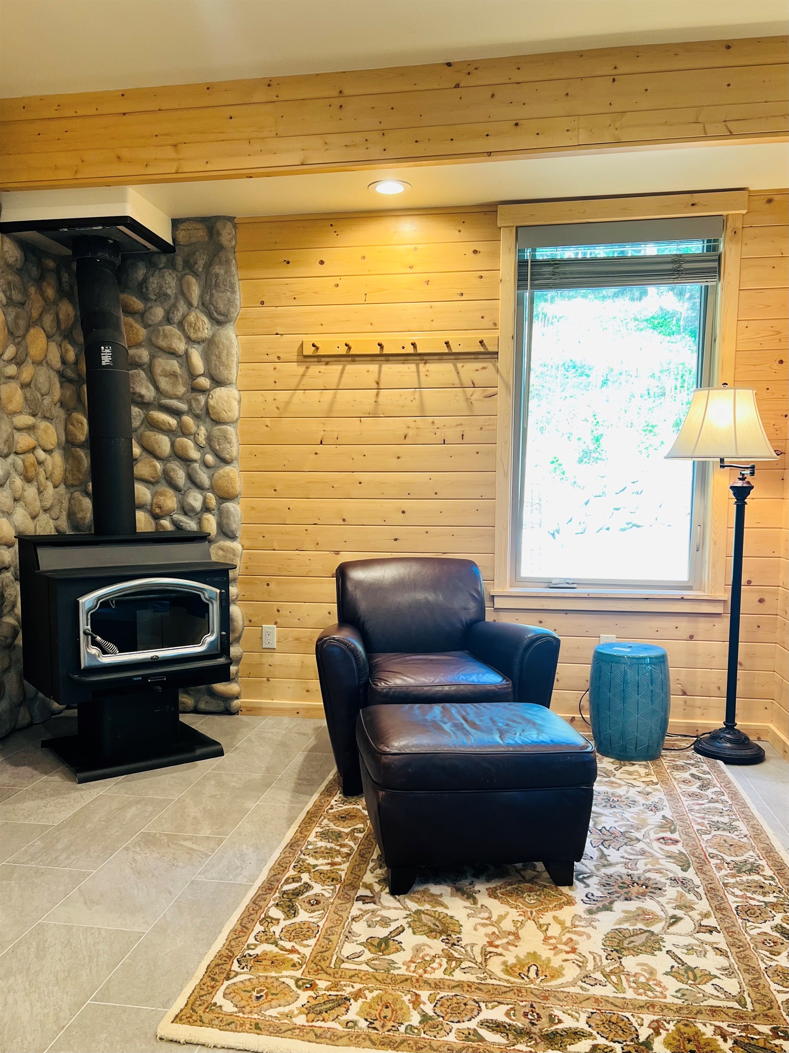 Rich leather armchair next to wood stove offers the perfect spot for a glass of wine or a nice book, A duraflame log is provided for your stay. Please do not cut wood in the house or on the patio
