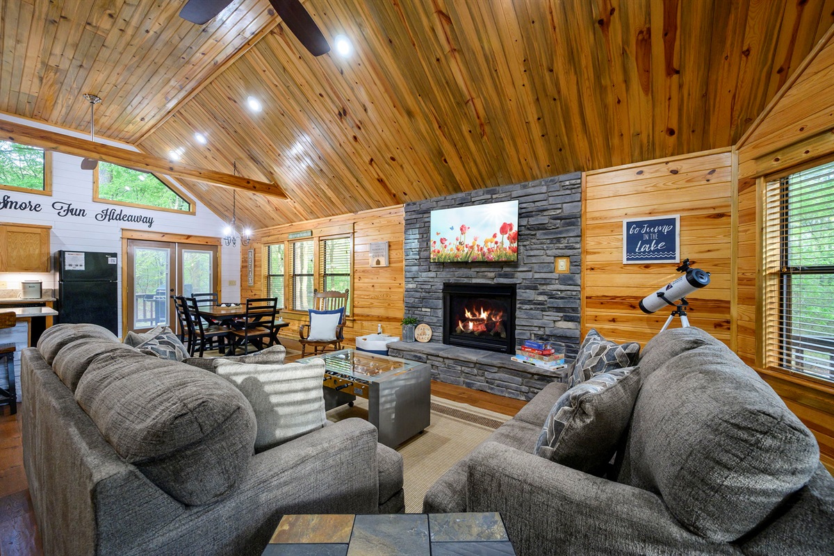 Open-concept living with soaring ceilings, fireplace, and cozy cabin charm 🏡