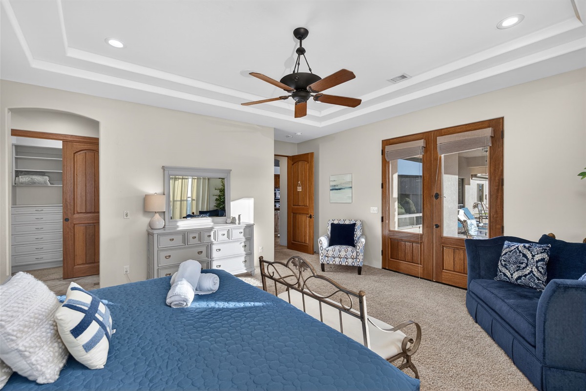 Spacious first-floor primary suite with king bed, private seating area, and direct access to a luxury ensuite bath