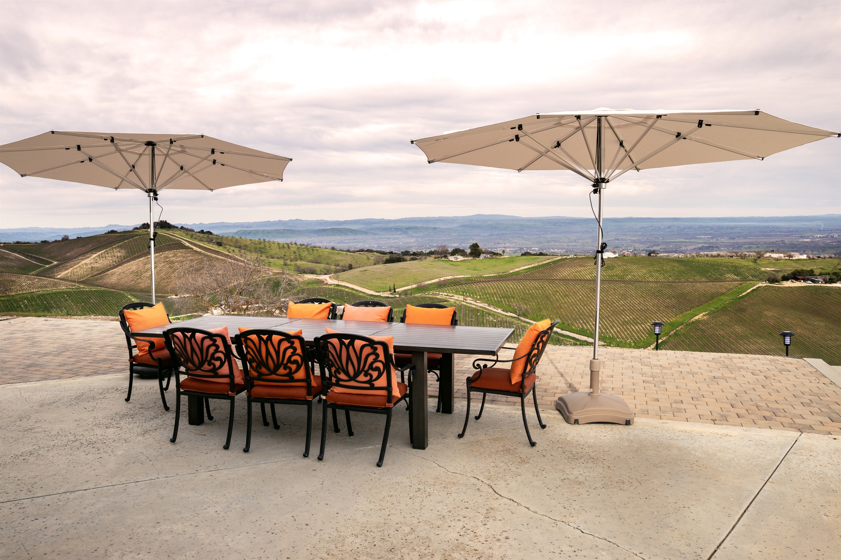 Ten seats, two umbrellas, and an uninterrupted panorama of the Adelaida wine country. The outdoor dining table was made for long lunches that turn into long evenings.