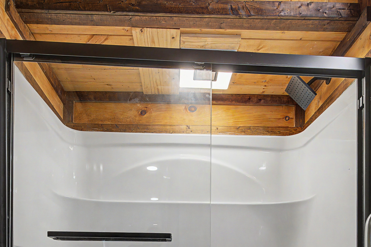 Spa-Like Bathroom Retreat: Enjoy spacious, modern showering with rustic wood accents!
