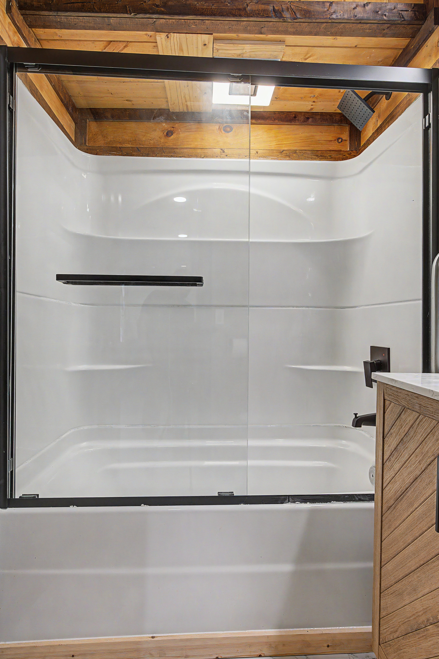 Spa-Like Bathroom Retreat: Enjoy spacious, modern showering with rustic wood accents!