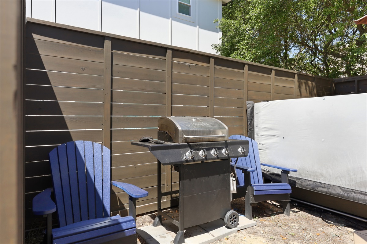 Private backyard patio with hot tub and propane grill