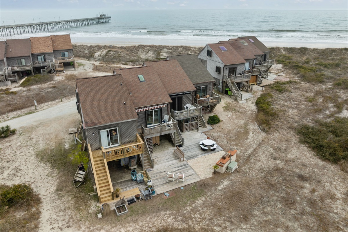 Aerial view showcasing beach access, dunes, and ocean beyond