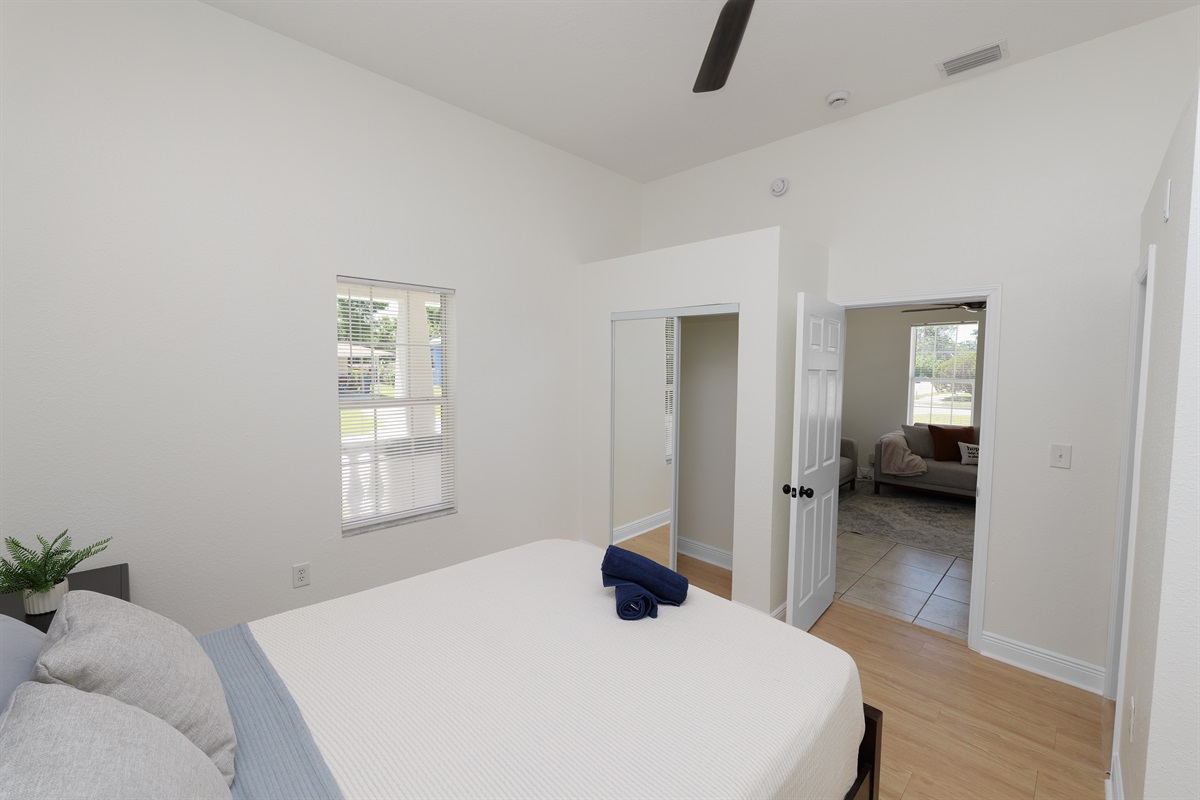 Drift off in a plush queen bed wrapped in crisp white linens, with soft pillows and a peaceful ambiance all around.
